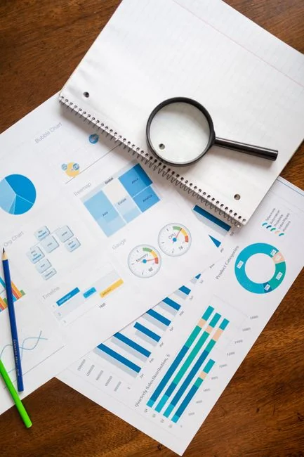Hands discussing vibrant data charts during a business meeting, with papers and diagrams.